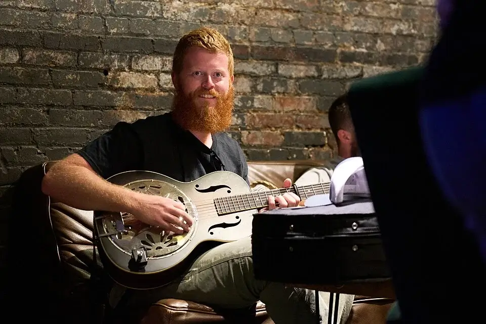 Oliver Anthony net worth singer with red beard playing resonator guitar