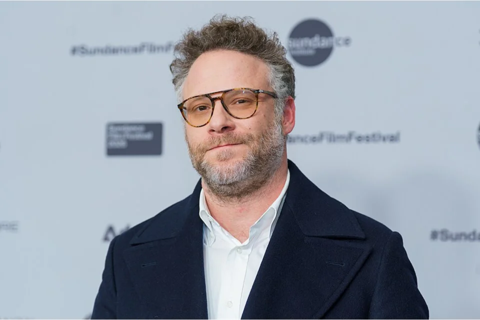 Seth Rogen on the red carpet at the Sundance Film Festival in a navy coat