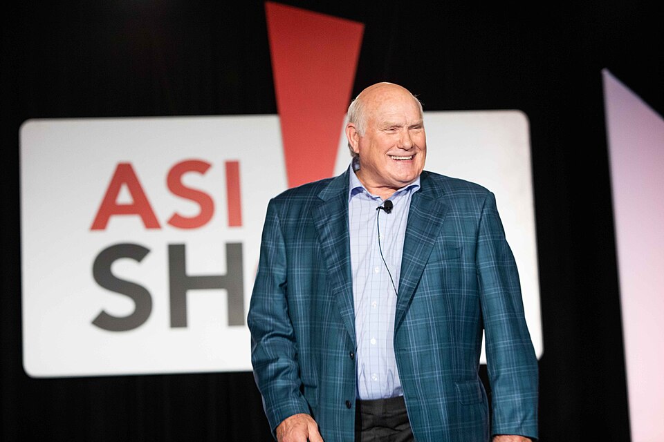 Terry Bradshaw speaking on stage at a corporate event mantlemagazine.com