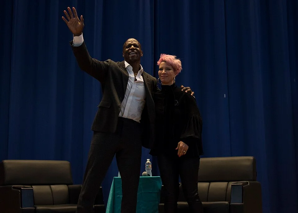 Terry Crews net worth — actor with wife Rebecca King-Crews on stage — mantlemagazine.com