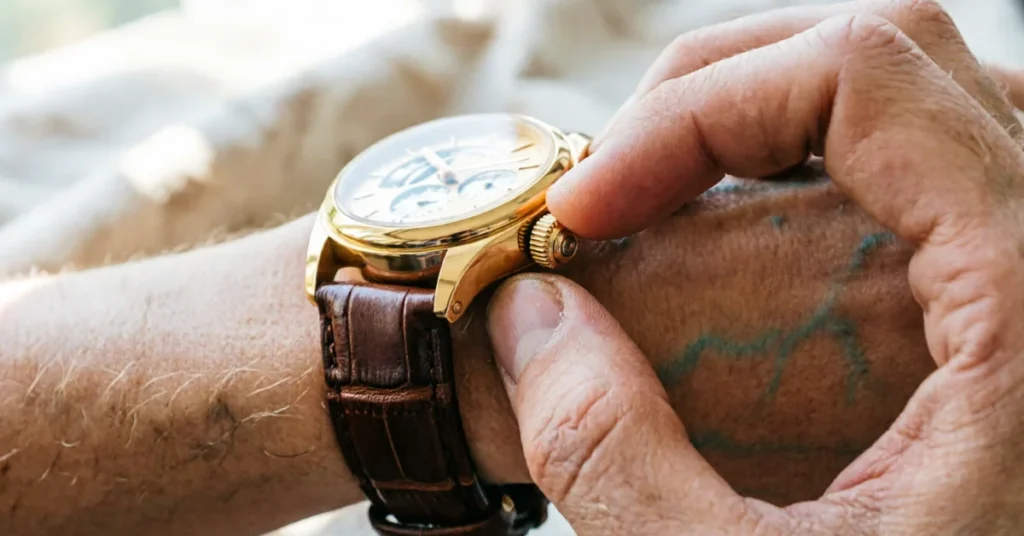 Person winding watch crown on wrist - chronograph with brown leather strap
