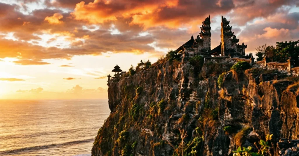 Bali Uluwatu temple sunset - cliff-top temple silhouette with orange sky - iconic Bali landmark