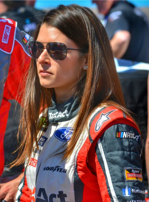 Danica Patrick in her Ford NASCAR racing suit with TaxAct and Goodyear sponsor patches at the track