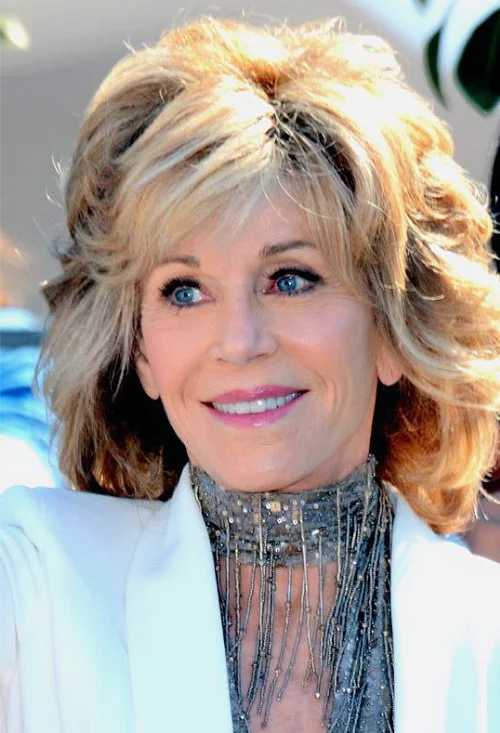 Jane Fonda, Ted Turner's third wife, smiling in a white blazer and sequined top