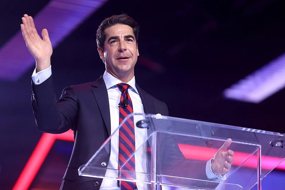 Jesse Watters speaking at a clear podium in a dark suit