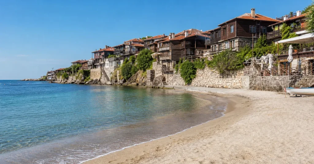 Best places to travel in August: wooden old-town houses over a quiet sandy beach on Bulgaria's Black Sea coast