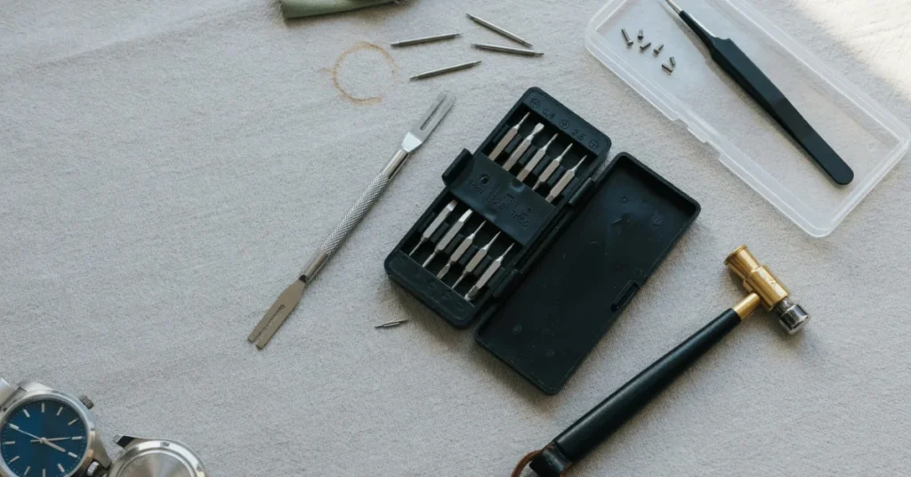 How do you adjust a Seiko watch band: flat-lay of a watch tool kit with screwdriver set, spring bar tool, small hammer, and spare pins