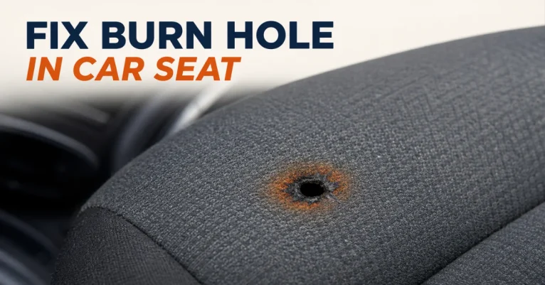 How to fix burn hole in car seat: close-up of a small burn hole with charred edges on gray cloth upholstery