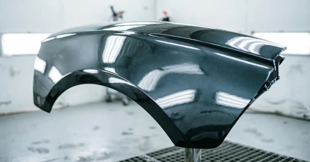 How to fix rust on a car: freshly painted fender with wet-look clear coat gloss in a paint booth
