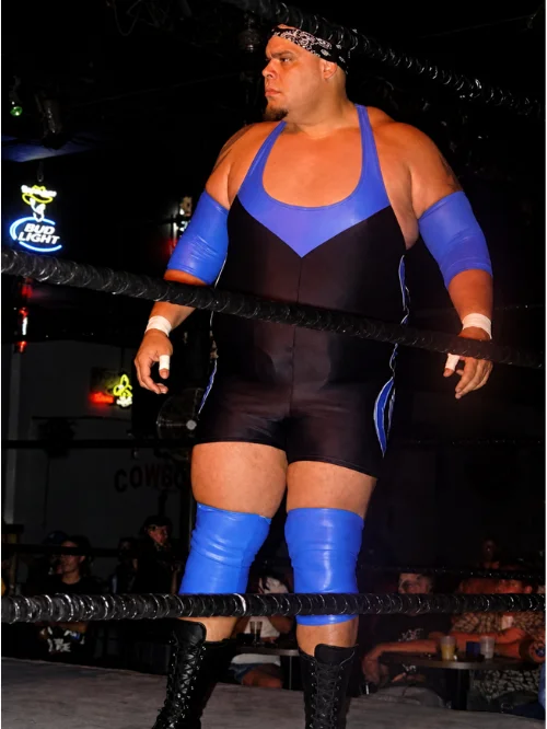 Tyrus in wrestling ring wearing black and blue singlet with blue knee pads during his professional wrestling career