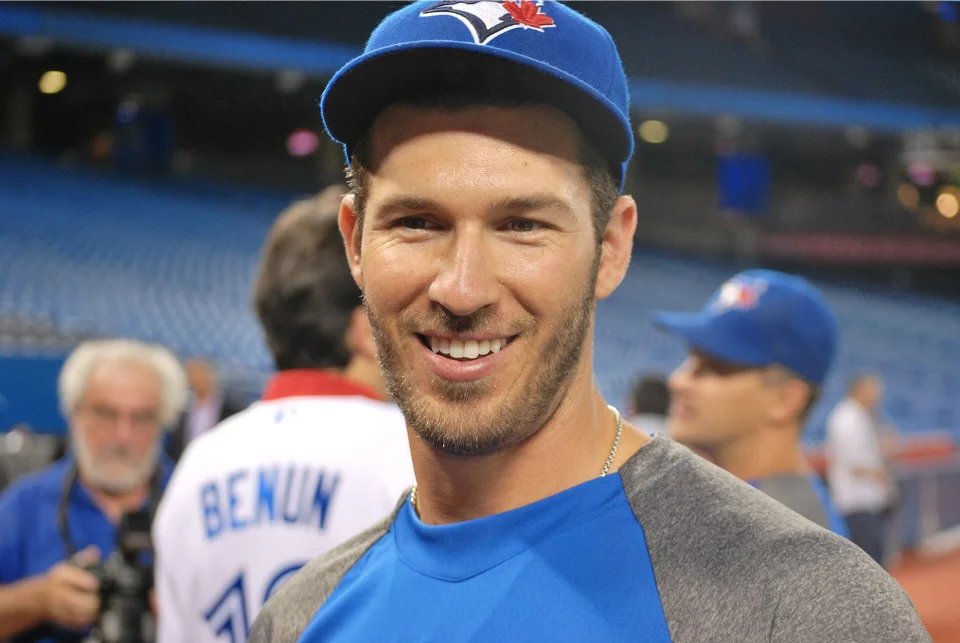 JP Arencibia smiling in a Toronto Blue Jays cap at the ballpark during his MLB career