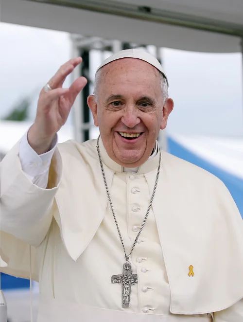 Pope Francis smiling and waving in white cassock and zucchetto with pectoral cross