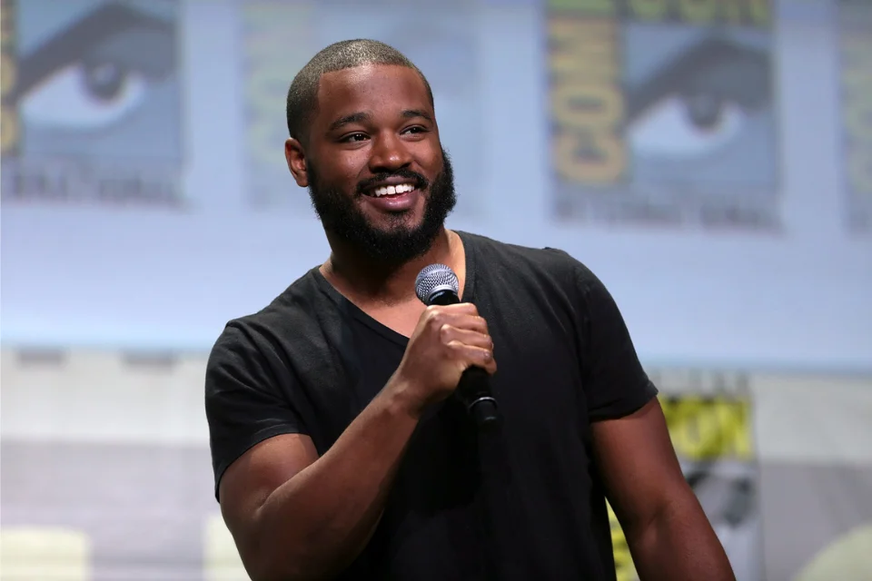 Ryan Coogler smiling with microphone at Comic-Con, stage of his Michael B. Jordan collaborations