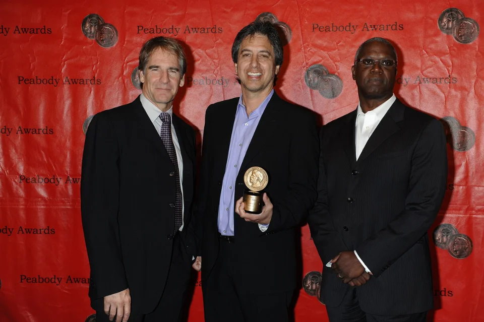 Ray Romano holding Peabody Award trophy with producers, celebrating Everybody Loves Raymond's critical success