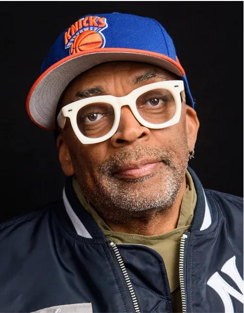 Spike Lee close-up portrait in Knicks cap, director with $60-70 million net worth
