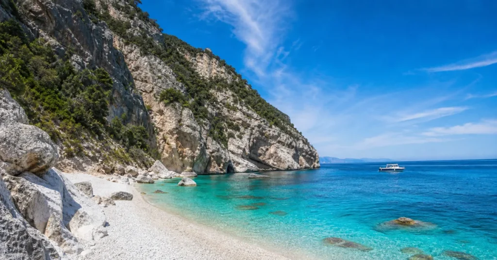 Best beaches in the Mediterranean: Cala Mariolu's white pebble beach with turquoise water and limestone cliffs in Sardinia