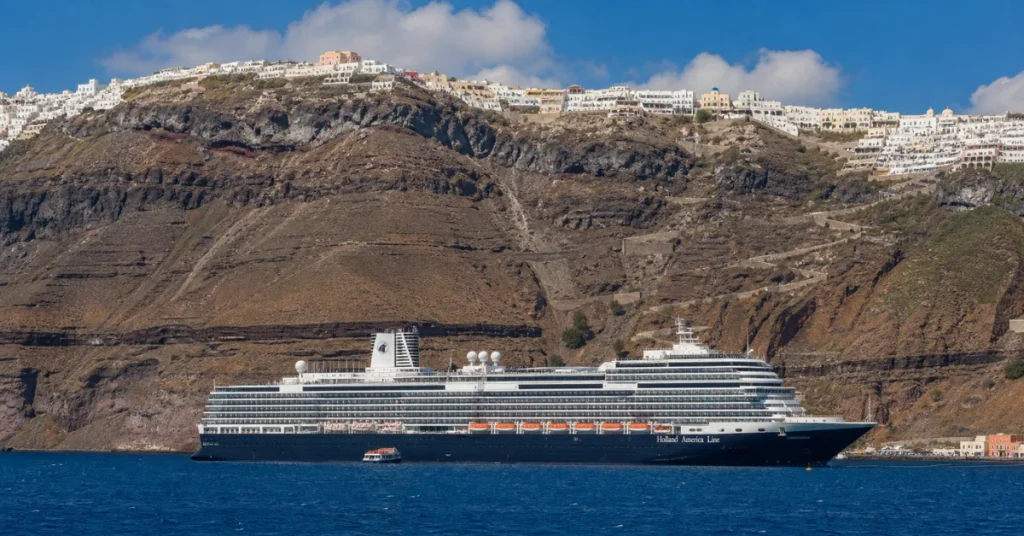 Best islands to visit in Greece: a cruise ship anchored below Santorini's caldera with the whitewashed town of Fira on the cliff above
