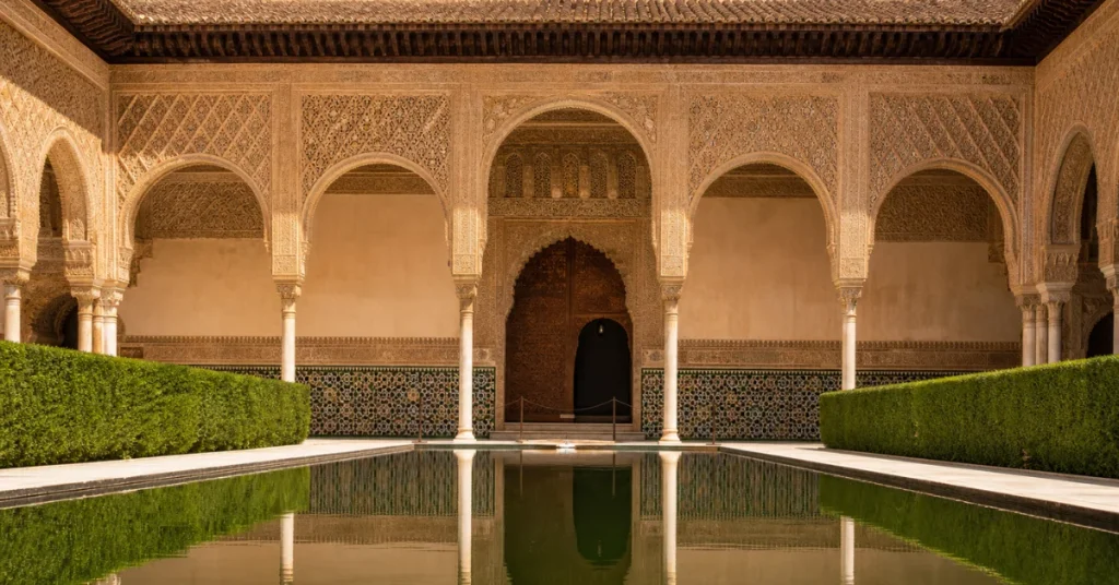 Tourist places to visit in Spain: the Nasrid Palace courtyard at the Alhambra in Granada showing intricate Moorish arches and reflecting pool