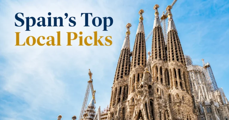 Tourist places to visit in Spain: the Sagrada Família's spires under construction against a blue sky in Barcelona