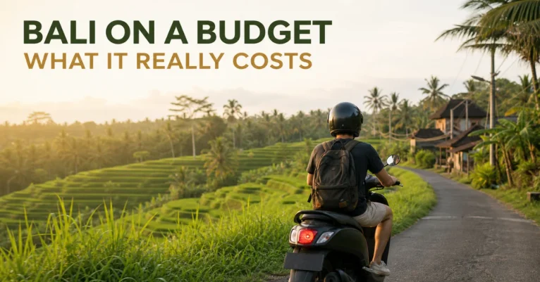 Visit Bali on a budget: a traveler riding a scooter past green rice terraces in warm golden light