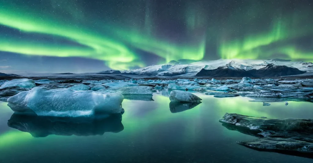 Best places to see the northern lights: aurora borealis reflected over Jökulsárlón glacier lagoon with icebergs in Iceland
